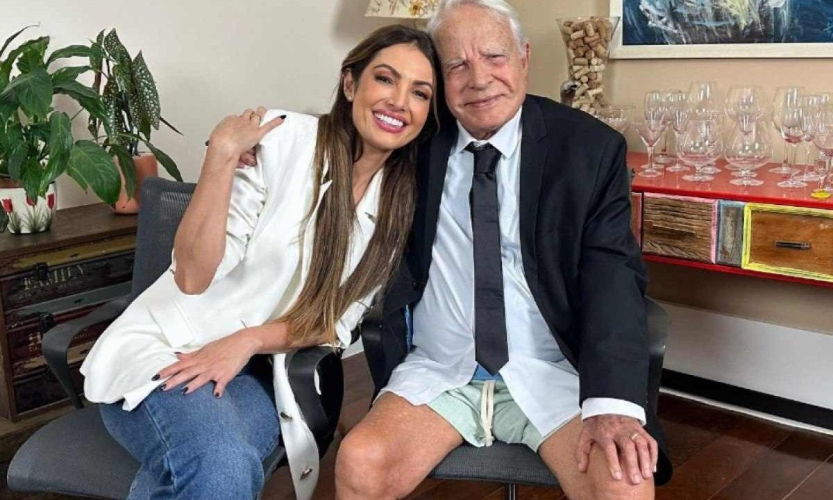 Patrícia Poeta sorri abraçada a Cid Moreira, vestido de bermudas, roupa que usou uma vez para apresentar o Jornal Nacional  -  (crédito: Reprodução/Instagram)