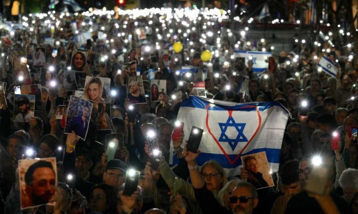 Argentinos em Buenos Aires homenageiam vítimas do ataque terrorista do Hamas em Israel com celulares acesos e fotos dos reféns
       -  (crédito: Luis ROBAYO / AFP)
