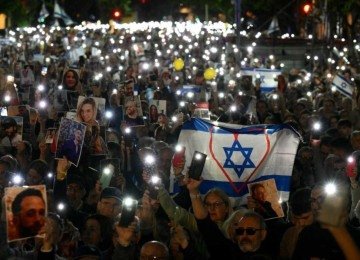 Argentinos em Buenos Aires homenageiam vítimas do ataque terrorista do Hamas em Israel com celulares acesos e fotos dos reféns
       -  (crédito: Luis ROBAYO / AFP)