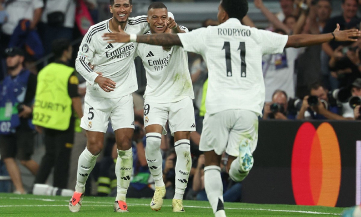  Real Madrid's French forward #09 Kylian Mbappe celebrates with Real Madrid's English midfielder #05 Jude Bellingham and Real Madrid's Brazilian forward #11 Rodrygo after scoring his team's first goal during the UEFA Champions League 1st round day 1 football match between Real Madrid CF and Stuttgart VFB at the Santiago Bernabeu stadium in Madrid on September 17, 2024. (Photo by Pierre-Philippe MARCOU / AFP)
     -  (crédito:  AFP)