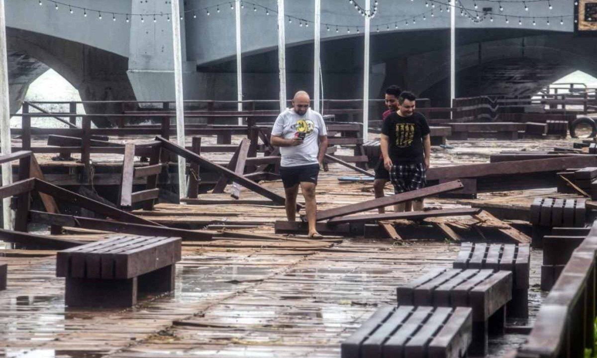Moradores caminham ao longo do cais danificado pelo furacão Milton, na costa de Puerto Progeso, no estado de Yucatán -  (crédito: HUGO BORGES / AFP)