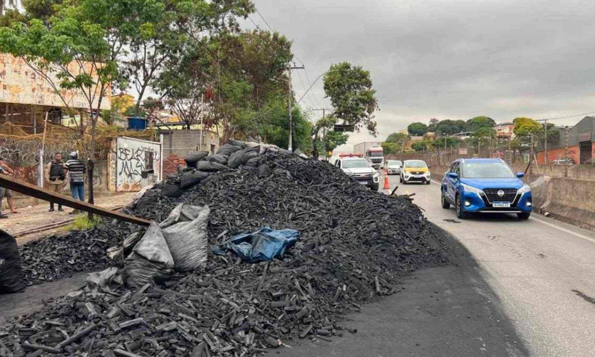 Caminhão carregado de carvão tombou e espalhou carga na pista da Avenida Cristiano Machado no sentido Aeroporto de Confins -  (crédito: Edesio Ferreira/EM/D.A Press)