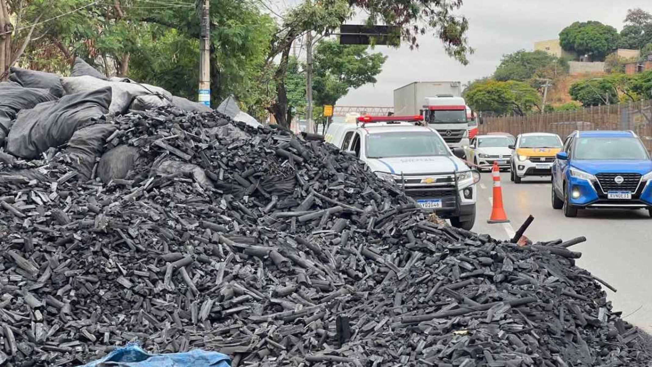 Caminhão carregado de carvão tombou e espalhou carga na pista da Avenida Cristiano Machado no sentido Aeroporto de Confins