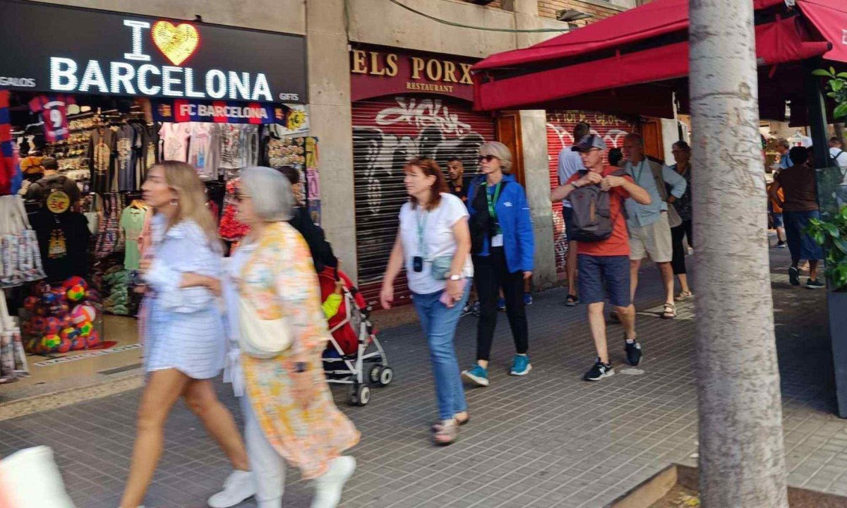 Manifestantes seguram faixa com dizeres 'Diminuição do turismo já' em protesto em julho  -  (crédito: Getty Images)