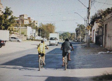 Na Avenida Francisco Negr&atilde;o de Lima, via de acesso ao Bairro C&eacute;u Azul, faltam cal&ccedil;adas e sinaliza&ccedil;&atilde;o, o asfalto &eacute; irregular e o mato alto &eacute; visto por todo lado -  (crédito: Alexandre Guzanshe/EM/D.A Press)