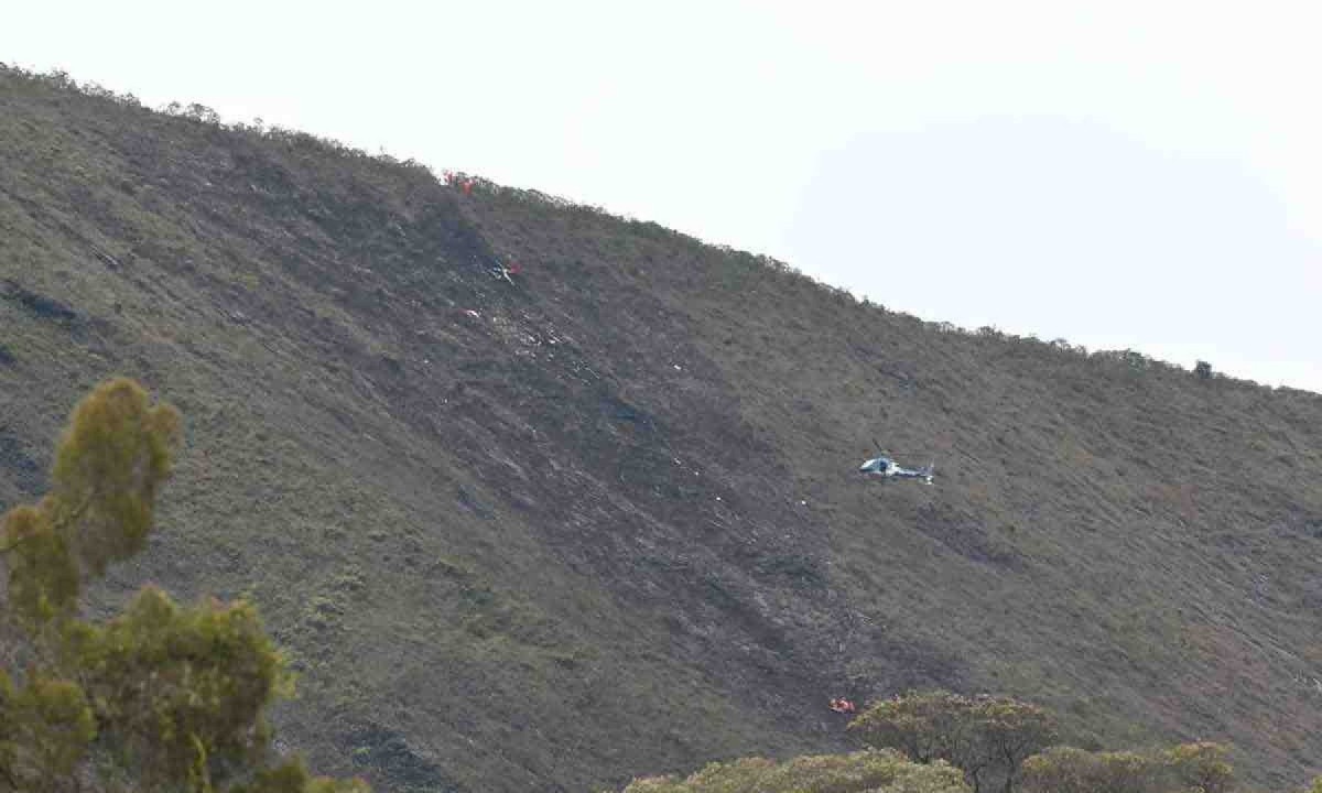 Aeronave e equipes de resgate atuam no local do desastre, poucos metros antes de vencer a crista da encosta: além das condições testemunhadas por socorristas, que dão pistas sobre momento do acidente, investigação vai considerar dados técnicos -  (crédito: Leandro Couri/EM/D.A Press)