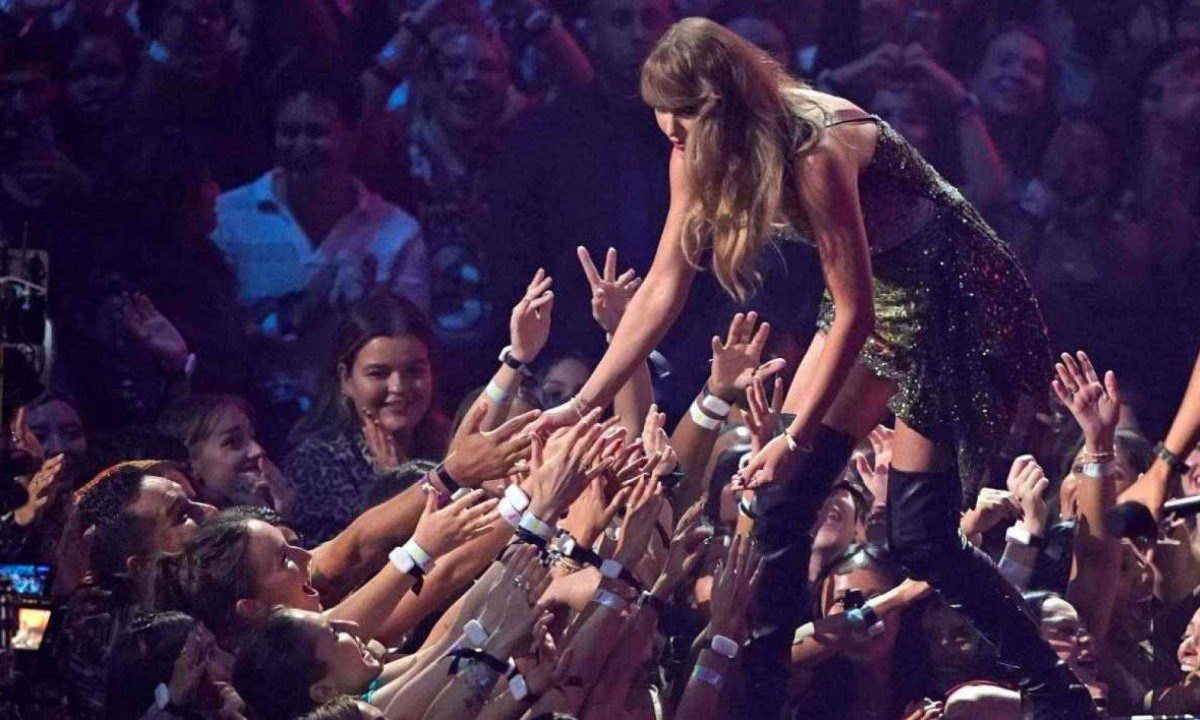 Fãs de Taylor Swift com a cantora -  (crédito: TIMOTHY A. CLARY / AFP)
