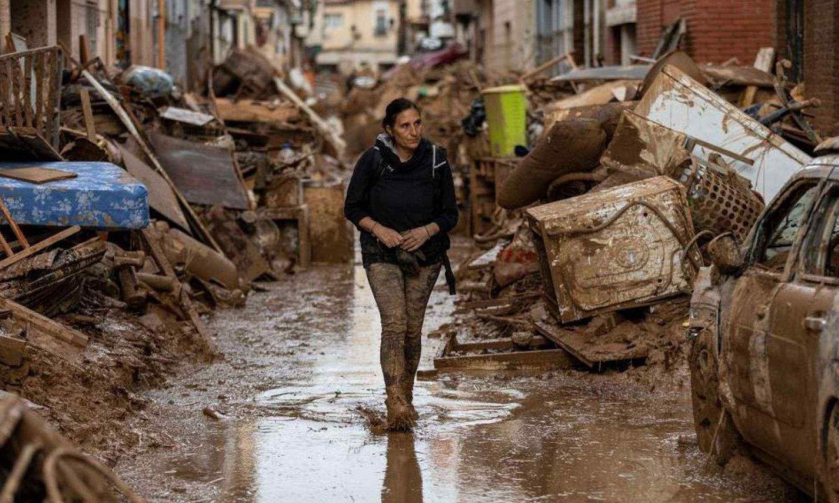 Uma rua em Valência em maio de 2024, e a mesma rua em novembro de 2024 coberta por carros destruídos amontoados  -  (crédito: BBC)