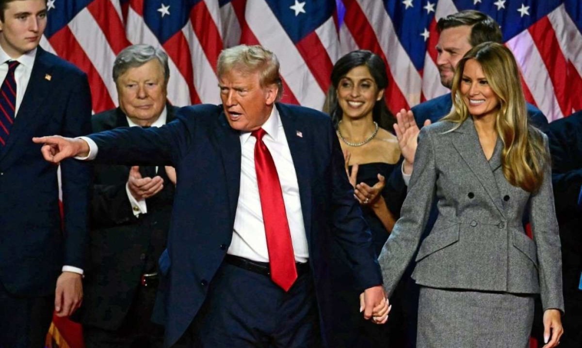 Donald Trump gesticula para os apoiadores depois de falar enquanto dá as mãos à ex-primeira-dama dos EUA Melania Trump -  (crédito: Jim WATSON / AFP)
