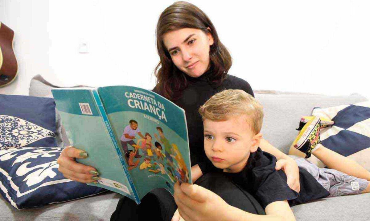 Carolina e o filho Lucca com a caderneta de vacina da criança: mãe aprova nova exigência, embora ainda não tenha recebido o pedido da escola -  (crédito: Marcos Vieira/EM/D.A Press)