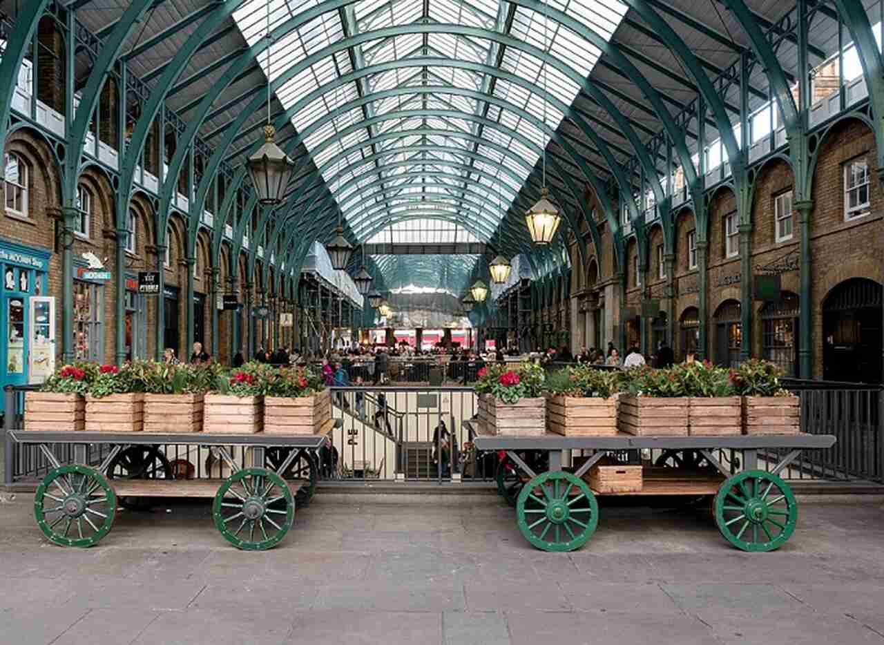 Covent Garden - Descrição: Originalmente um mercado de frutas e vegetais do século XVII, Covent Garden é agora uma área vibrante conhecida por seus teatros, lojas, restaurantes e artistas de rua - Localização: West End - Referências Históricas: A Royal Opera House, uma das principais casas de ópera do mundo, está localizada aqui