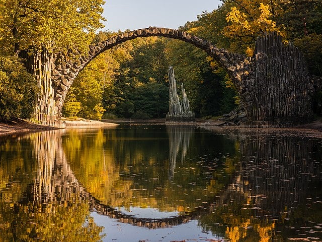 A ponte foi projetada para parecer um arco perfeito quando refletida nas águas abaixo, criando uma ilusão de círculo completo. 