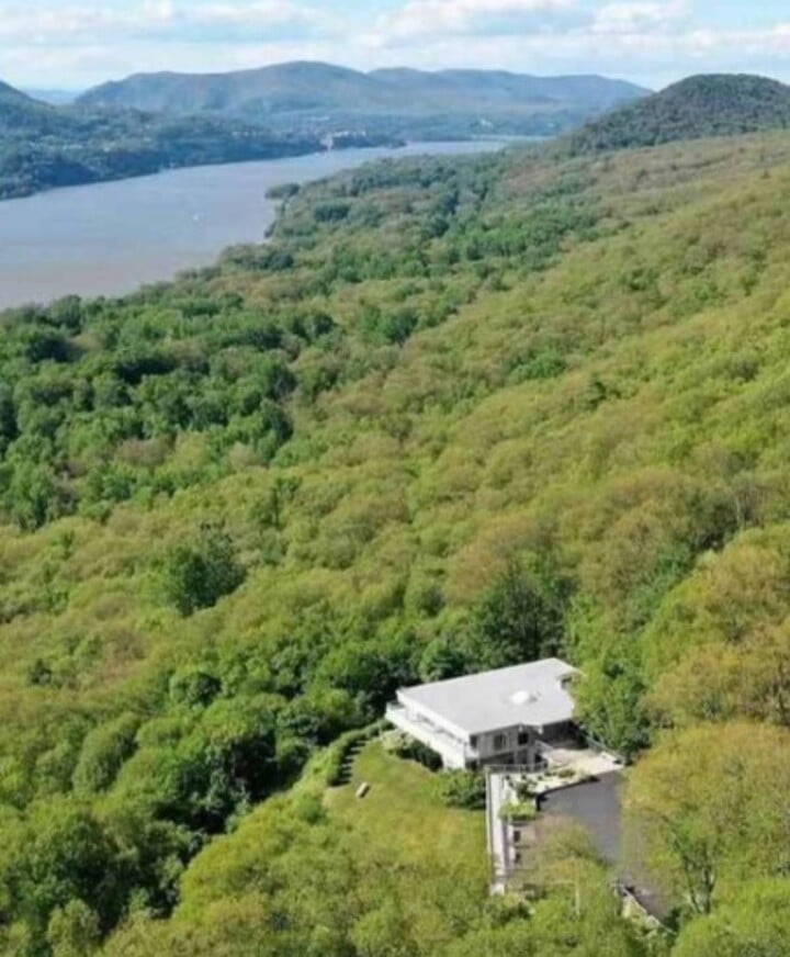 Com três andares, a propriedade fica isolada no alto de uma colina cercada por árvores e possui uma vista privilegiada de 180 graus do famoso rio Hudson. 

