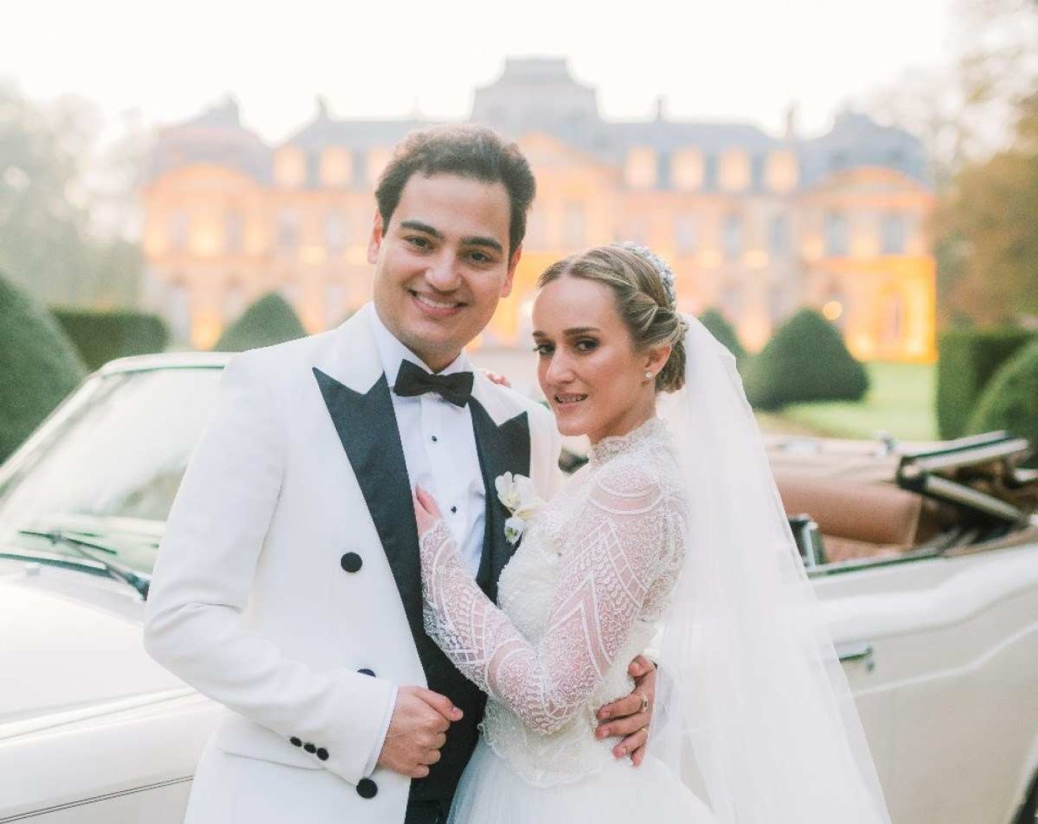 Os noivos Rafael Carvalhaes e Isabella de Lima posam para foto. Ao fundo, vê-se castelo francês
