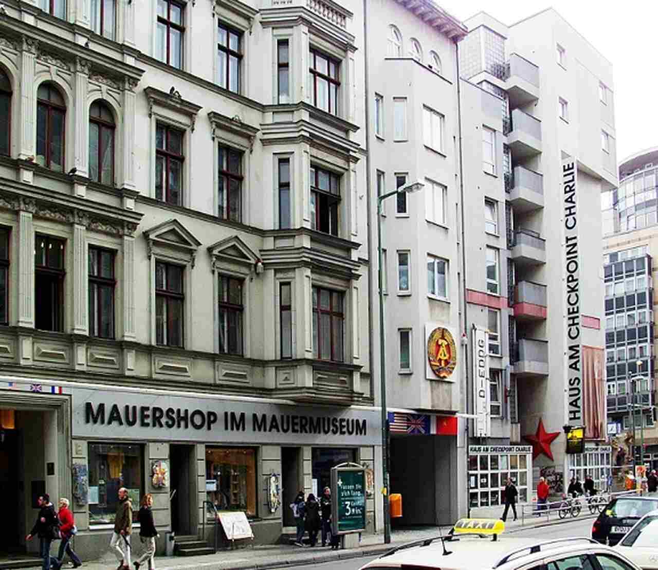 Checkpoint Charlie - Descrição: Checkpoint Charlie foi o posto militar mais famoso durante a Guerra Fria, situado na fronteira entre Berlim Oriental e Ocidental. Hoje, é um ponto turístico com um museu que documenta a história do muro - Localização: Friedrichstraße - Referências Históricas: O local simboliza as tensões da Guerra Fria e as tentativas dramáticas de fuga