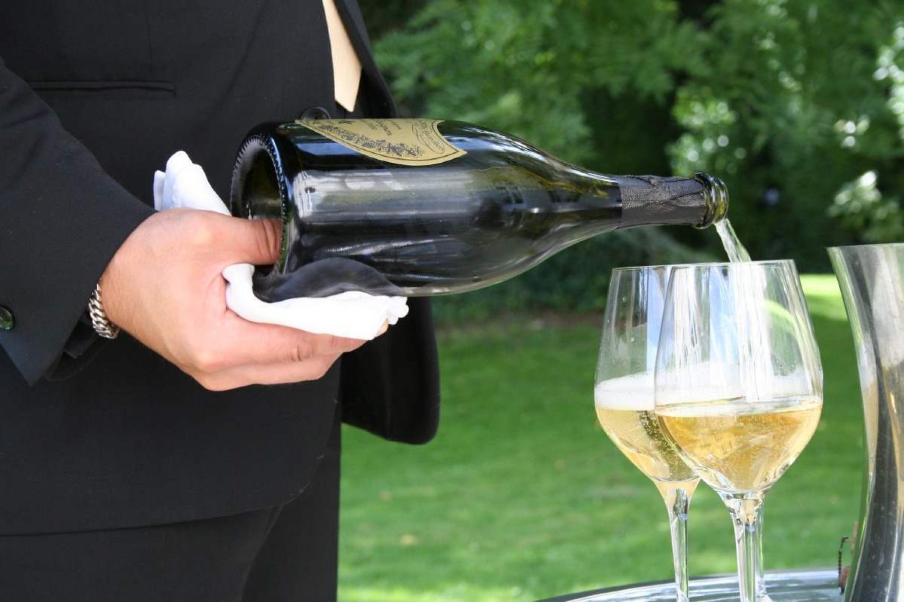 Garçam serve champanhe Dom Perignon em taças