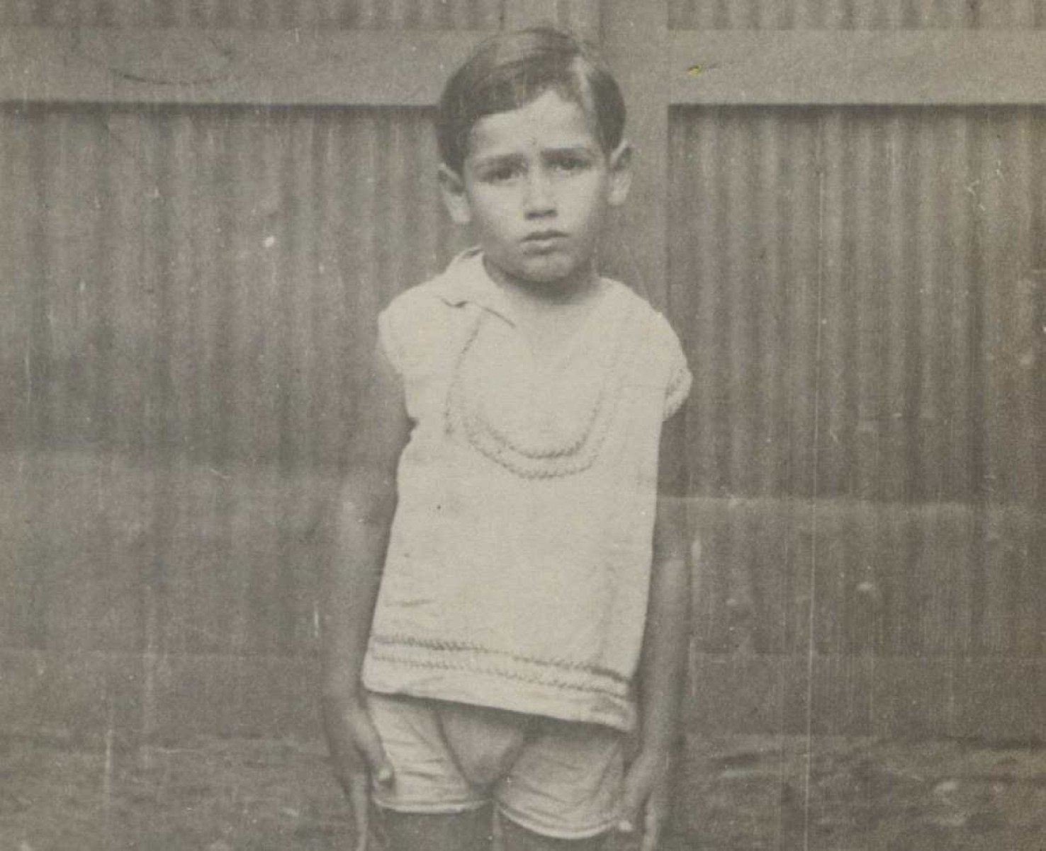 Foto de Fernando Sabino, ainda criança, que olha para a câmera e tem o semblante triste