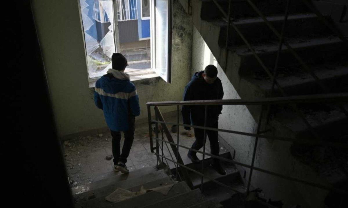 Viajante espanhol Alberto Blasco Ventas (à esquerda) visita edifício residencial danificado perto de Kiev
       -  (crédito: Genya SAVILOV / AFP)