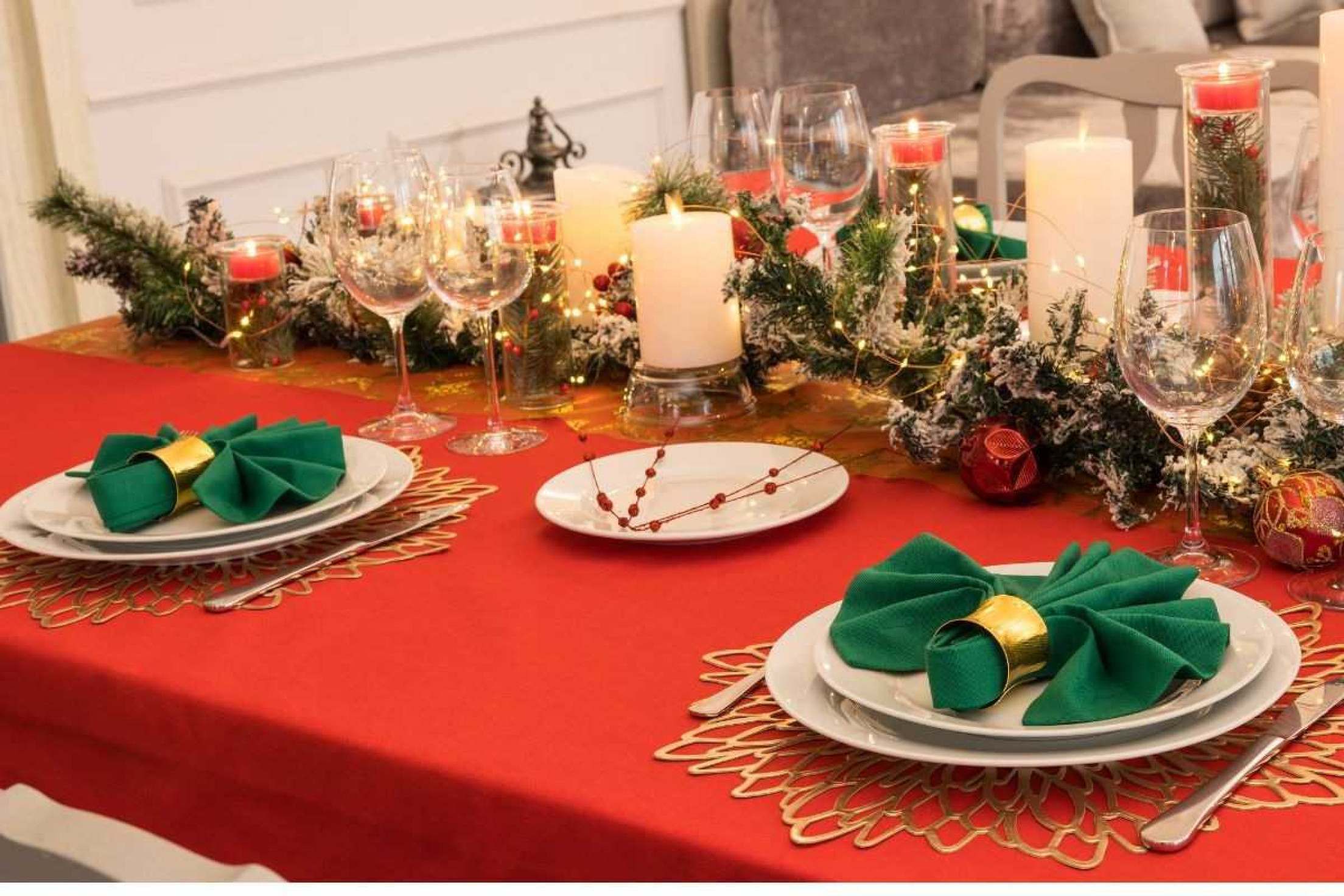 Mesa decorada com toalha vermelha e dourada, capturando o espírito do Natal