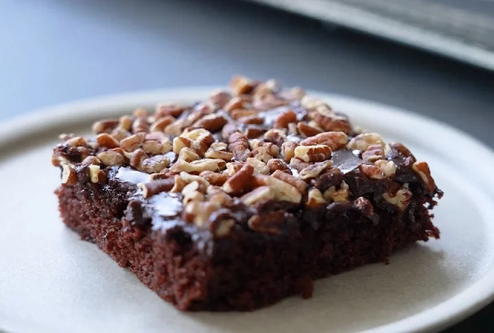 Tradicionalmente, o bolo — ainda morno — é coberto com uma cobertura de chocolate quente que é despejada por cima, criando uma camada cremosa que se funde levemente com a massa, proporcionando uma textura marcante. 