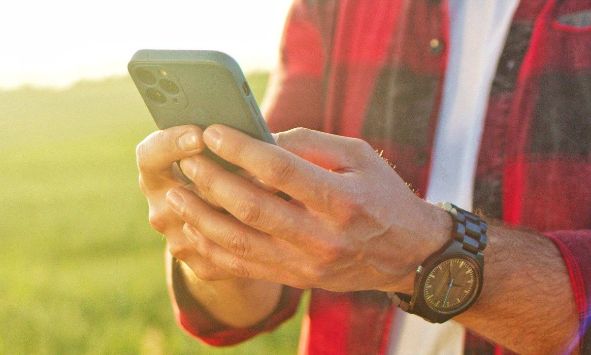  Cropped view of the optimistic caucasian farmer scientist in plaid shirt using smartphone mobile technology application while working at the field and smiling. Agriculture concept
     -  (crédito:  ihorvsn - stock.adobe.com)