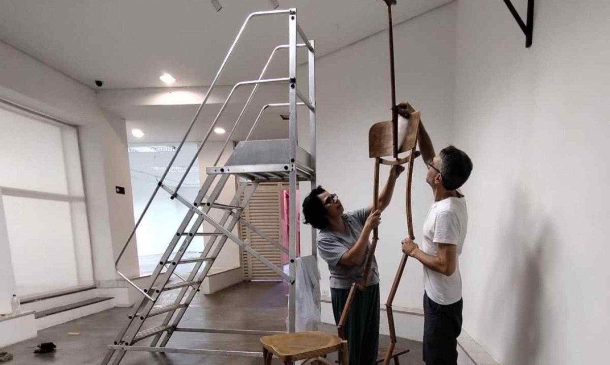 Cláudia França monta a cadeira suspensa de um dos ambientes da exposição "Em casa" -  (crédito: Cláudia França/Divulgação)