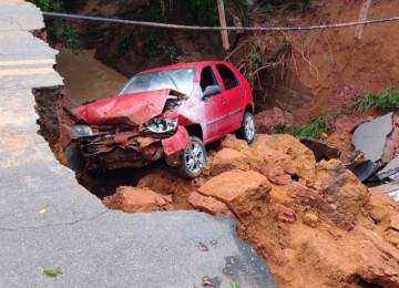 Dois carros foram engolidos em cratera que abriu depois de chuvas; acidente causou três mortes e deixou dois feridos -  (crédito: Reprodução/Redes sociais)