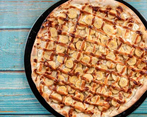 Banana nevada - Entre as sugestões de pizzas doces esta, composta por um recheio feito com bananas em rodelas, além de chocolate branco, açúcar e canela. Sugerida por Forneria Gagliasso. 