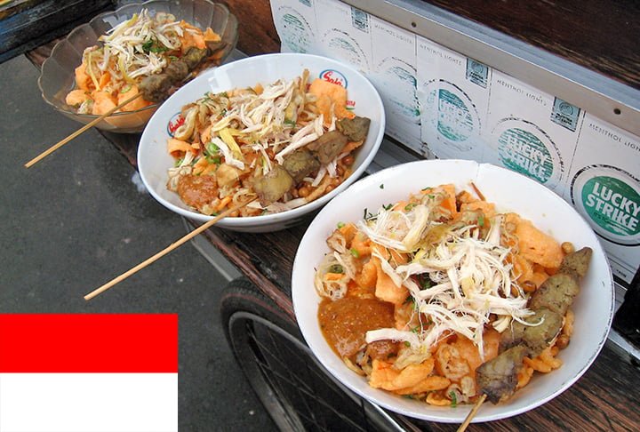13º lugar - Bubur ayam (Indonésia) -Mingau de arroz com carne de frango desfiada servido com alguns condimentos, como cebolinha picada, chalota frita crocante, aipo, tongcay, soja frita, crullers e molho de soja salgado e doce, e às vezes coberto com caldo de galinha amarelo e kerupuk.-Gunkarta - Wikimédia Commons