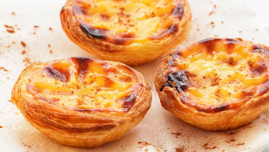 1º - Pastel de nata (Portugal): É um tradicional pastel de nata português popular em todo o mundo. Acredita-se que para melhor resultado o recheio não deve ser muito doce e não deve ter sabores de limão nem baunilha. Em vez disso, as tortas devem ser polvilhadas com canela e, de preferência, acompanhadas de uma xícara de café.