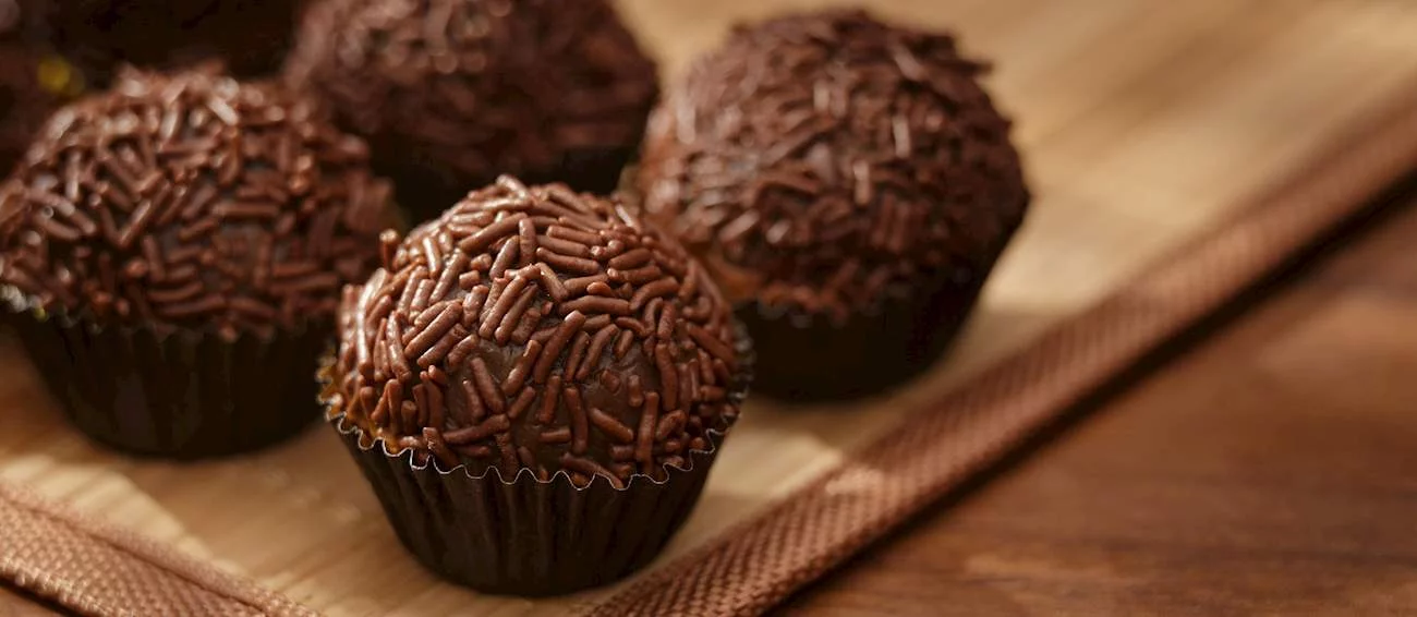 36º - Brigadeiro (Brasil): É uma sobremesa brasileira feita pelo aquecimento de três ingredientes principais - manteiga sem sal, cacau em pó e leite condensado, que são então enrolados em uma pequena bola, com formato semelhante a uma trufa. Feito pela primeira vez na década de 1940, quando faltavam frutas e doces, o brigadeiro nasceu da criatividade com poucos ingredientes.