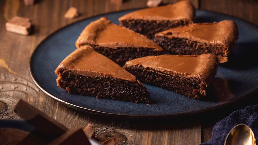 5º - Kladdkaka (Suécia): Uma das sobremesas suecas mais populares é um rico bolo de chocolate conhecido como kladdkaka. Esta clássica criação sueca combina ovos, cacau (ou chocolate), manteiga, açúcar e farinha em uma sobremesa densa e deliciosa. Durante o cozimento, o bolo deve permanecer sempre úmido no centro, enquanto a camada externa se transforma em uma camada fina e crocante.