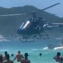 Vídeo: policial em helicóptero deixa fuzil cair no mar e banhista devolve - Reprodução/Redes Sociais