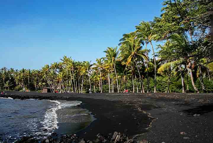 Praia de Punalu’u – Ilha Grande, Havaí, EUA - Famosa por sua areia preta vulcânica, resultante da lava basáltica que esfria rapidamente ao tocar o oceano.