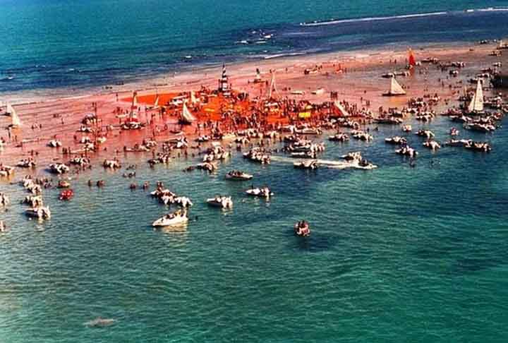 Praia da Areia Vermelha – Cabedelo, Paraíba - Localizada em um banco de areia que aparece na maré baixa, sua coloração avermelhada vem dos sedimentos ricos em ferro. A praia forma uma paisagem única em contraste com o mar esverdeado.