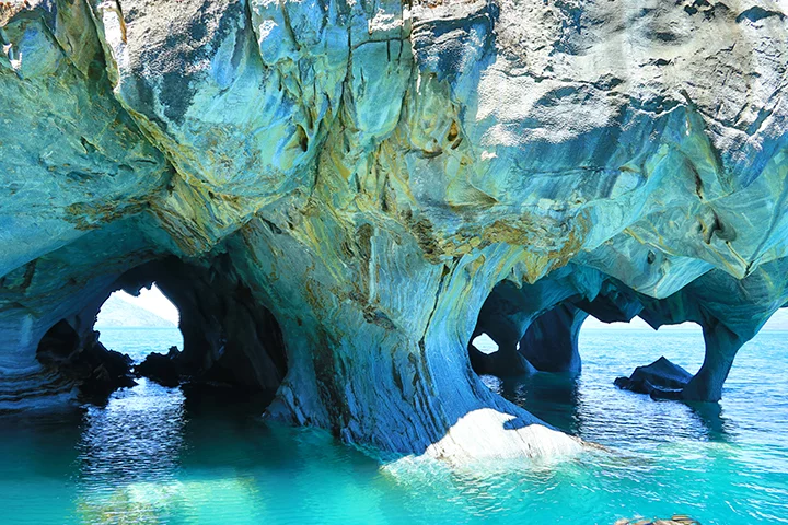  E ganham nuances que se destacam na água de tom azul-turqueza (proveniente do degelo glacial), que penetra as cavernas no Lago General Carrera.. 