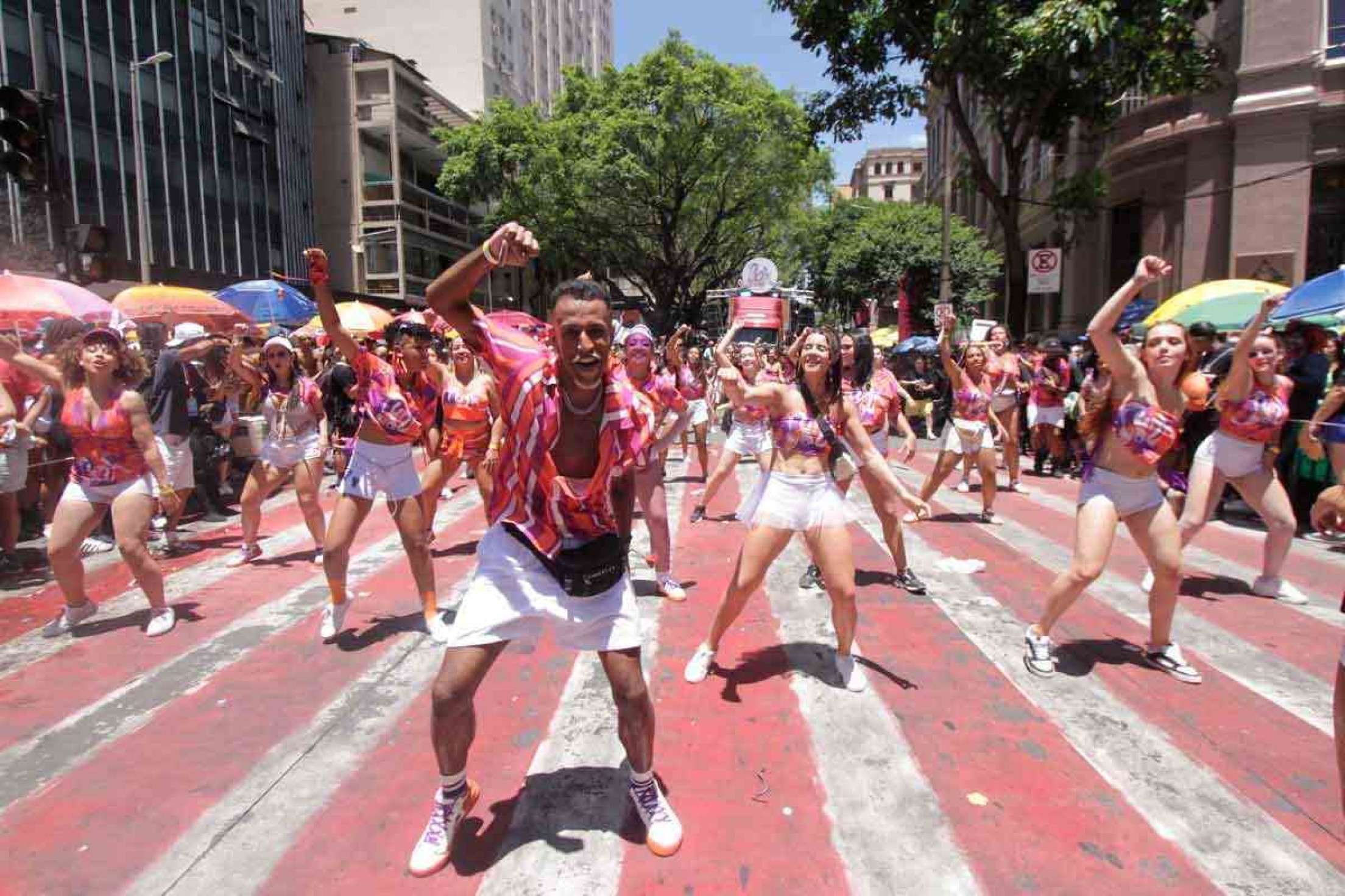 desfile do bloco funk you na carnaval de belo horizonte de 2024, no destaque os integrantes fazem uma coreografia em que todos estão com os braço direito levantado 