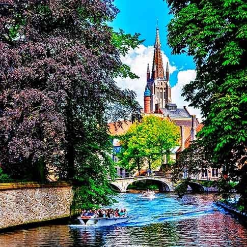 Bruges, Bélgica – Os encantadores passeios de barco pelos canais de Bruges são uma das formas mais românticas de explorar essa cidade medieval. Com pontes pitorescas e ruas de paralelepípedos, oferece uma viagem pelo tempo, imersa em história e arquitetura flamenga. A cidade é um dos destinos mais charmosos da Europa, especialmente na primavera, quando as flores estão em plena floração.
