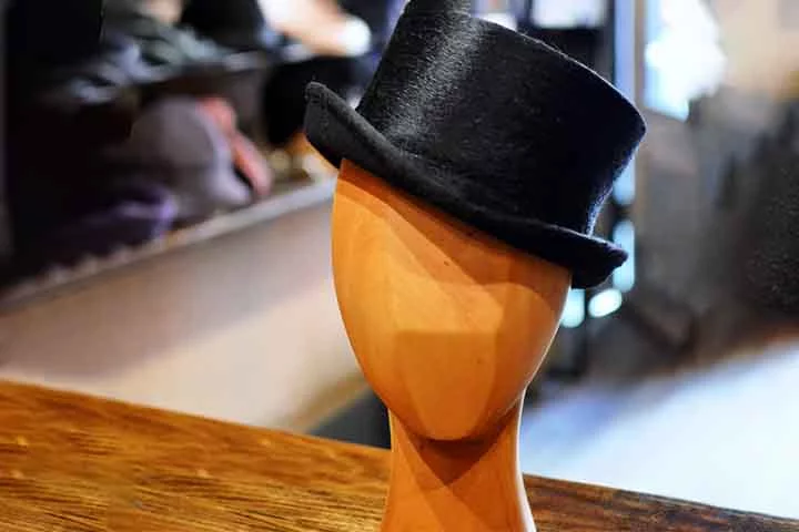 O top hat, ou chapéu alto, é feito de feltro ou seda e é um símbolo de classe e elegância. Tradicionalmente usado em eventos formais e cerimônias, ele é frequentemente associado a casamentos e festas de gala