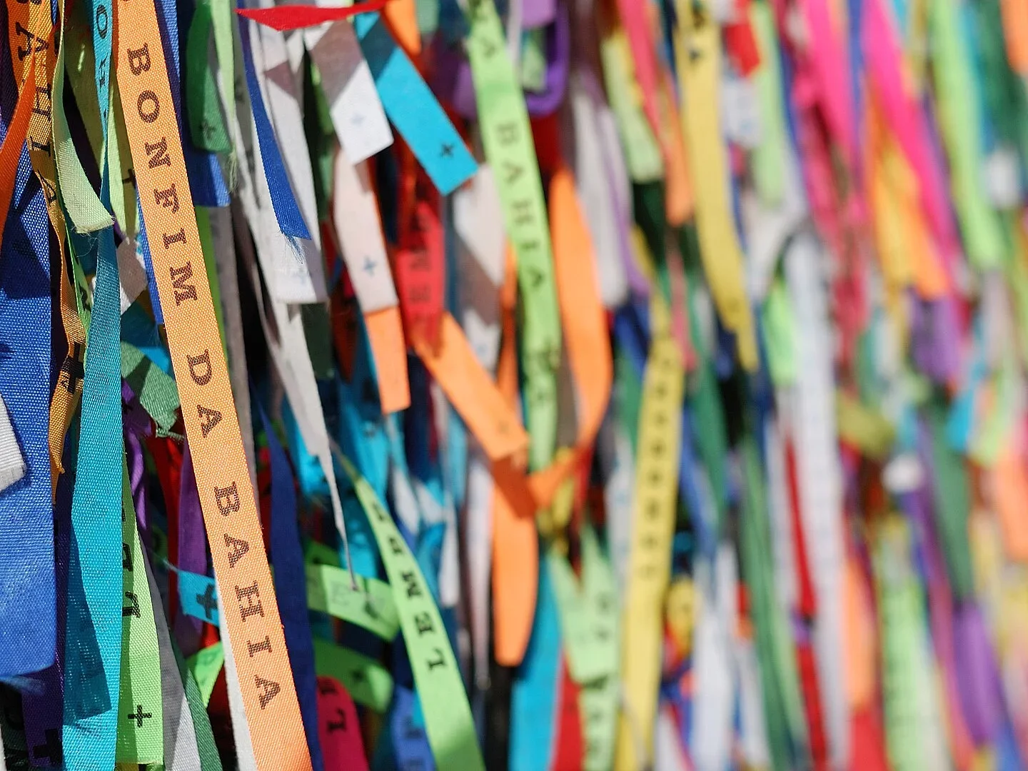 Fita do Senhor do Bonfim- Um amuleto brasileiro, que simboliza proteção e sorte. Feita de tecido colorido, é encontrada em lojas de artesanato ou igrejas. Usada para fazer pedidos ou como adorno, deve ser retirada apenas quando se desfaz completamente, simbolizando a realização dos desejos e a proteção contínua do Santo baiano.-Rosino wikimedia commons