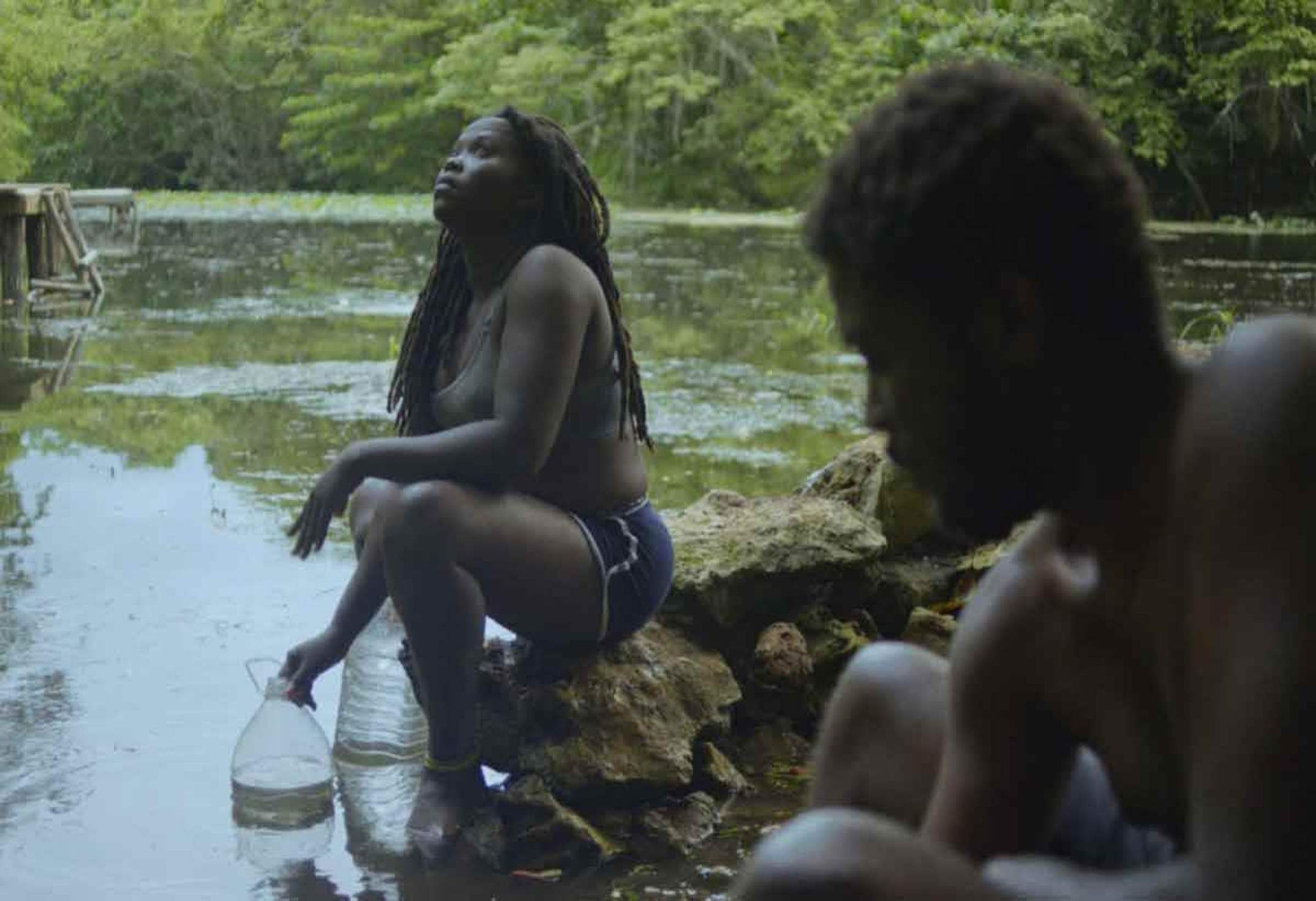 Casal negro na beira de um rio no filme Anba dlo