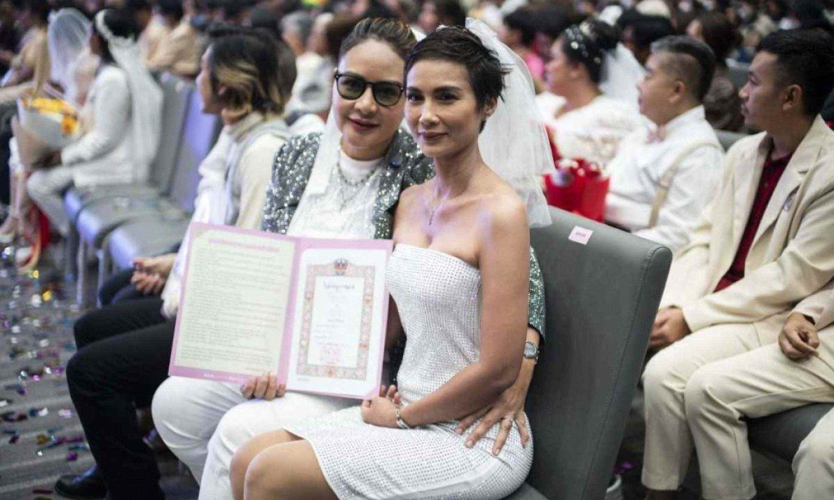 Ruchaya Nillakan (esquerda) e Nuttimon Sanyamast, casal do mesmo sexo, participam do registro de casamento em Bangkok na Tailândia, juntamente com outras centenas de casais -  (crédito: Chanakarn Laosarakham / AFP)