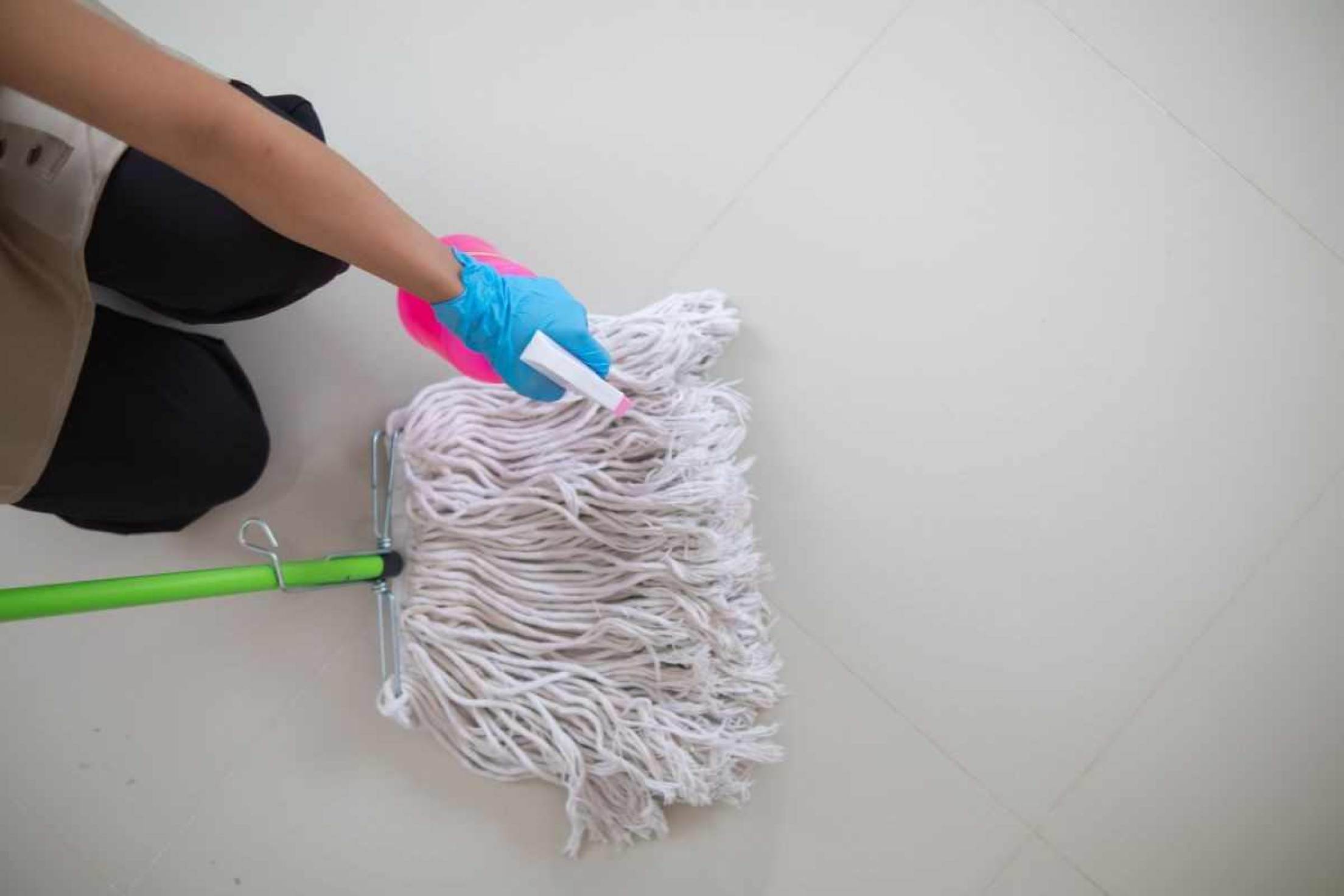 É possível transformar sua casa em um lugar mais seguro e protegido contra agentes infecciosos Pessoa com um esfregão e borrifador