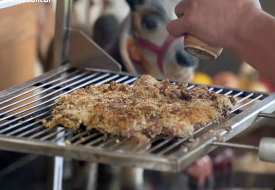 No vídeo, o churrasqueiro usou filé mignon, mas dá pra usar fraldinha, contrafilé e até patinho. Um pedaço de carne deve ser mergulhado em ovos para garantir que a farinha de rosca grude de maneira uniforme. Cubra a carne com a farinha e bote 60 cm acima do fogo para não queimar. 