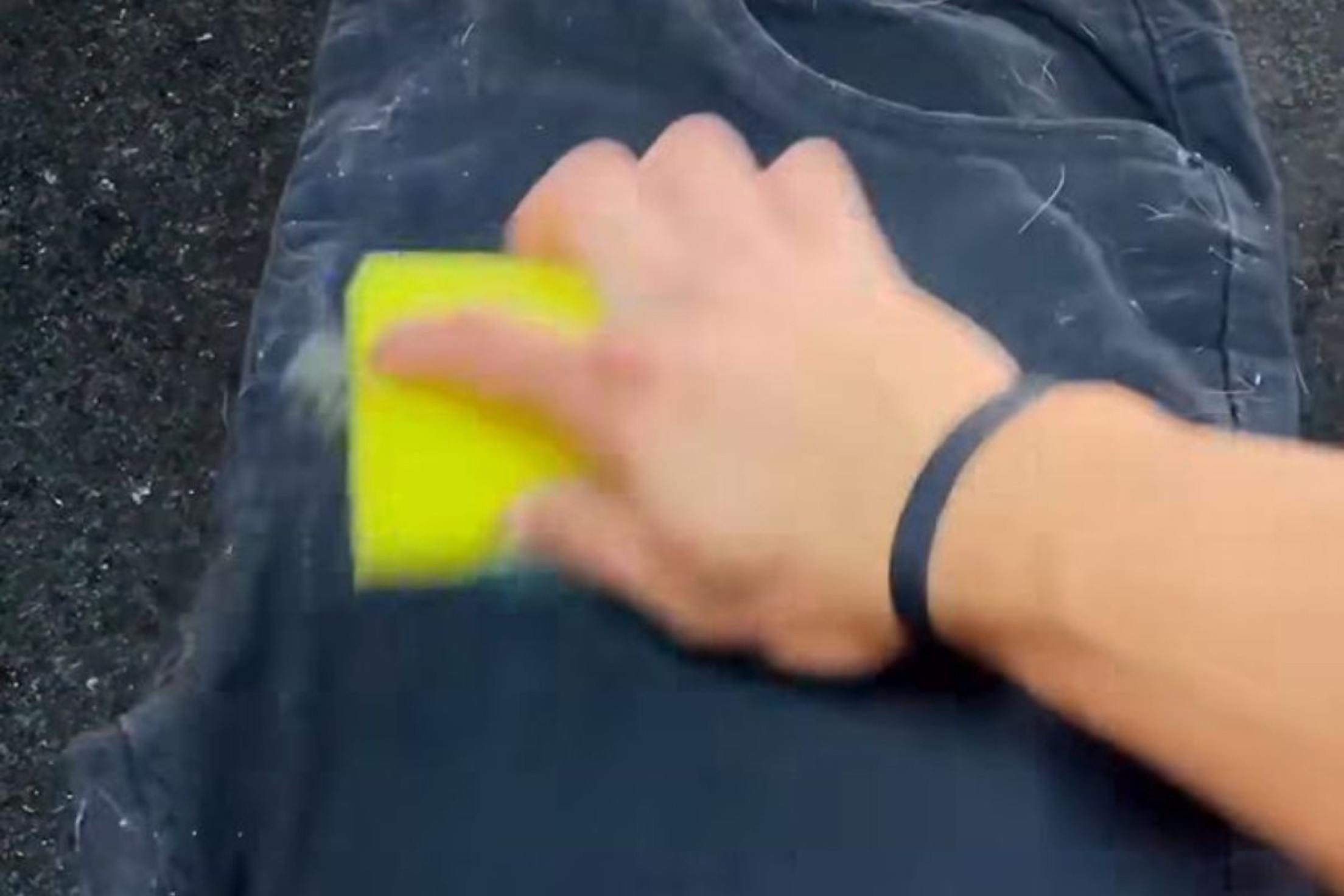 Esponja amarela sendo utilizada para retirar pelo das roupas