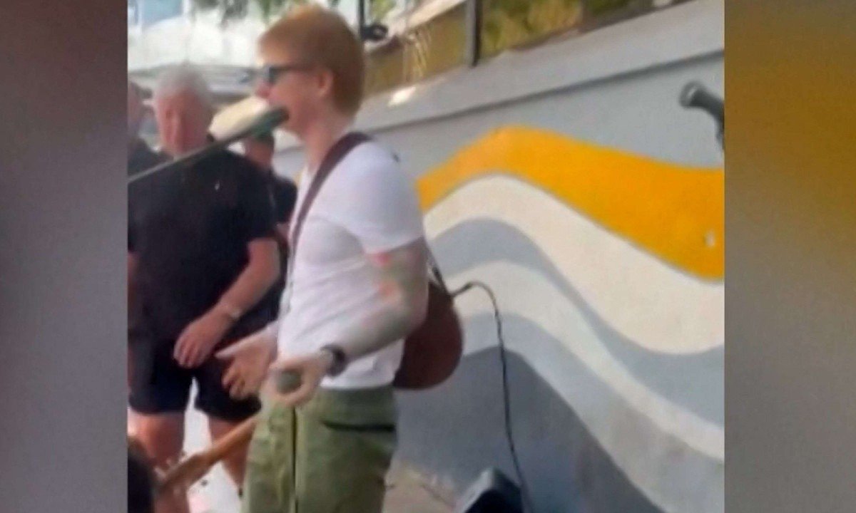 Ed Scheeran não pôde continuar apresentação em rua da Índia depois que o microfone em que cantava foi desligado por um policial -  (crédito: Reprodução/AFP/Dailymotion)