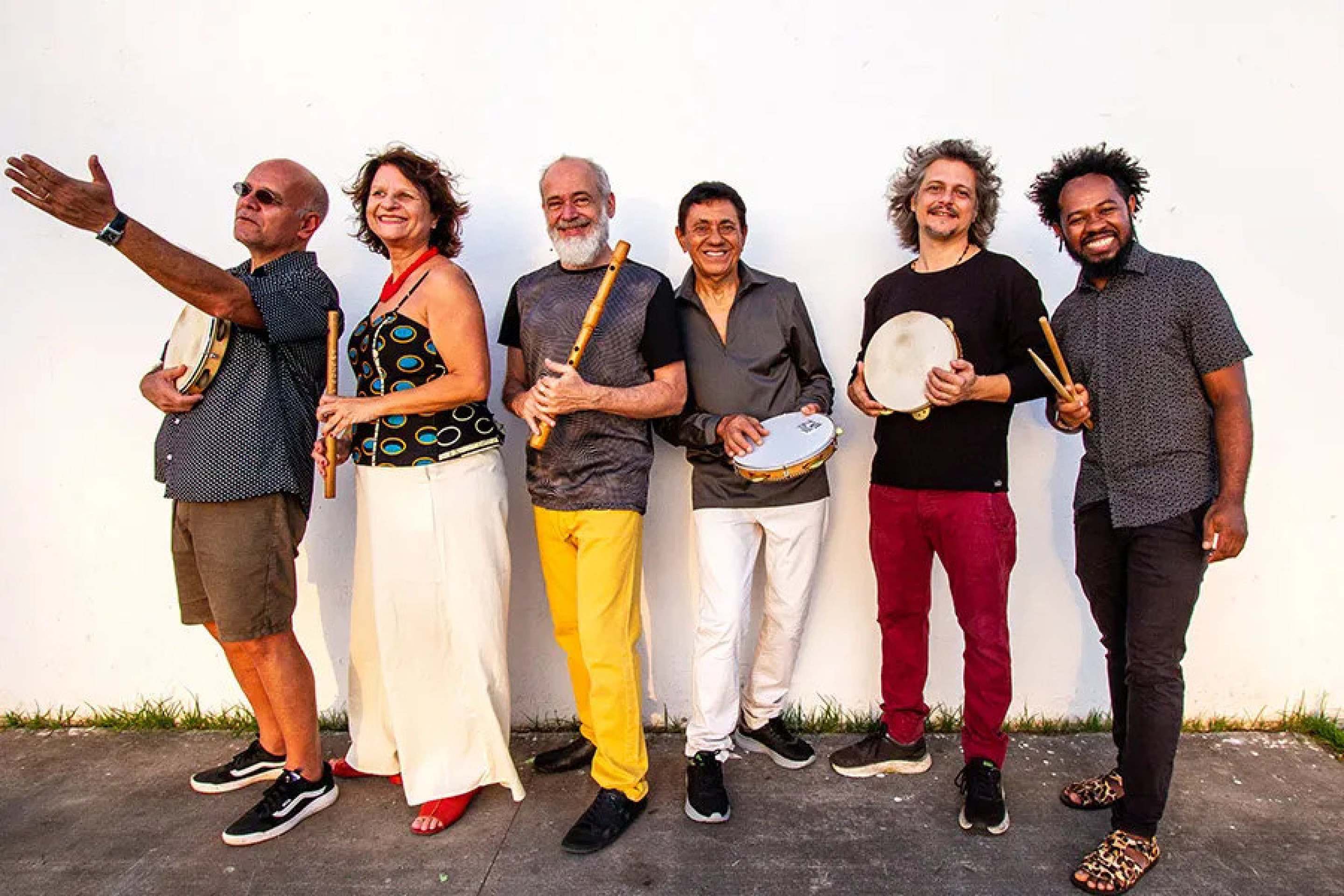 Grupo Carlos Malta e Pife Muderno, criado em 1994, aposta no diálogo da música popular brasileira com linguagens contemporâneas Seis músicos do grupo Pife Muderno estão de lado, em fila, e sorriem para a câmera
