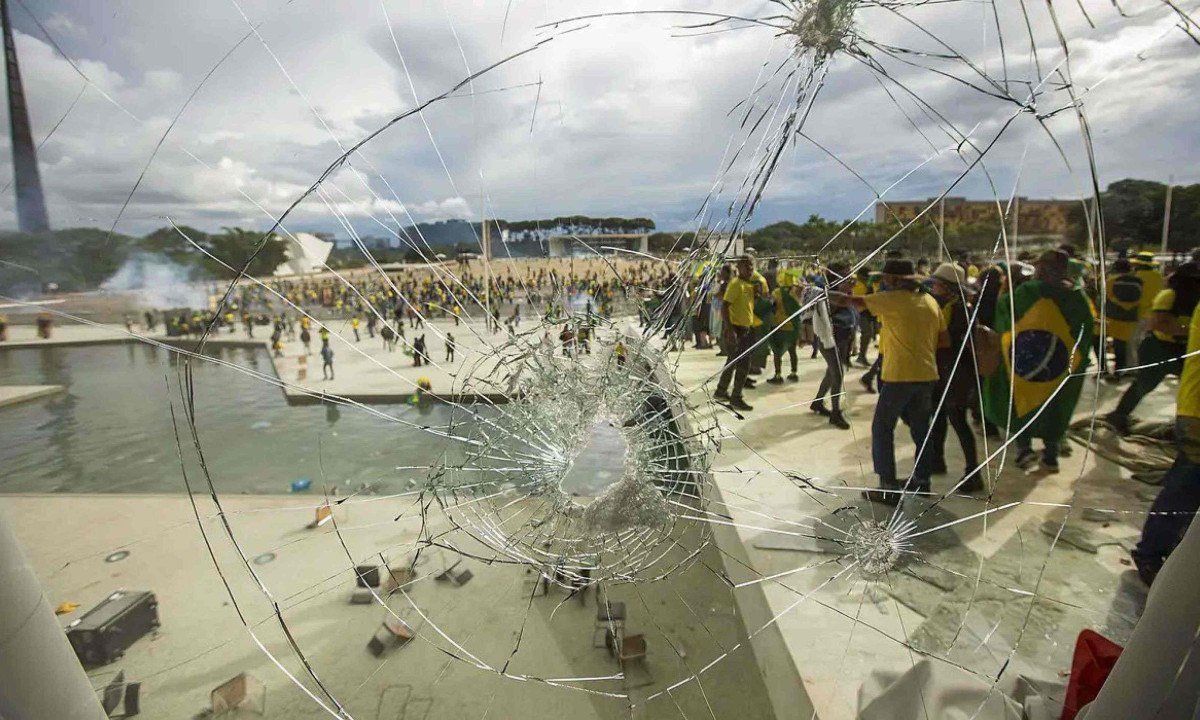 Pelo vidro quebrado em protesto violento na Praça dos Três Poderes, veem-se os vândalos que atacaram o Palácio do Planalto, o Congresso Nacional e o STF -  (crédito: EBC)