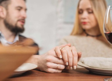 Casal de namorados, sentados à mesa, conversam sobre como estabelecer regras para o relacionamento em contrato, situação muito comum atualmente -  (crédito: Freepik)
