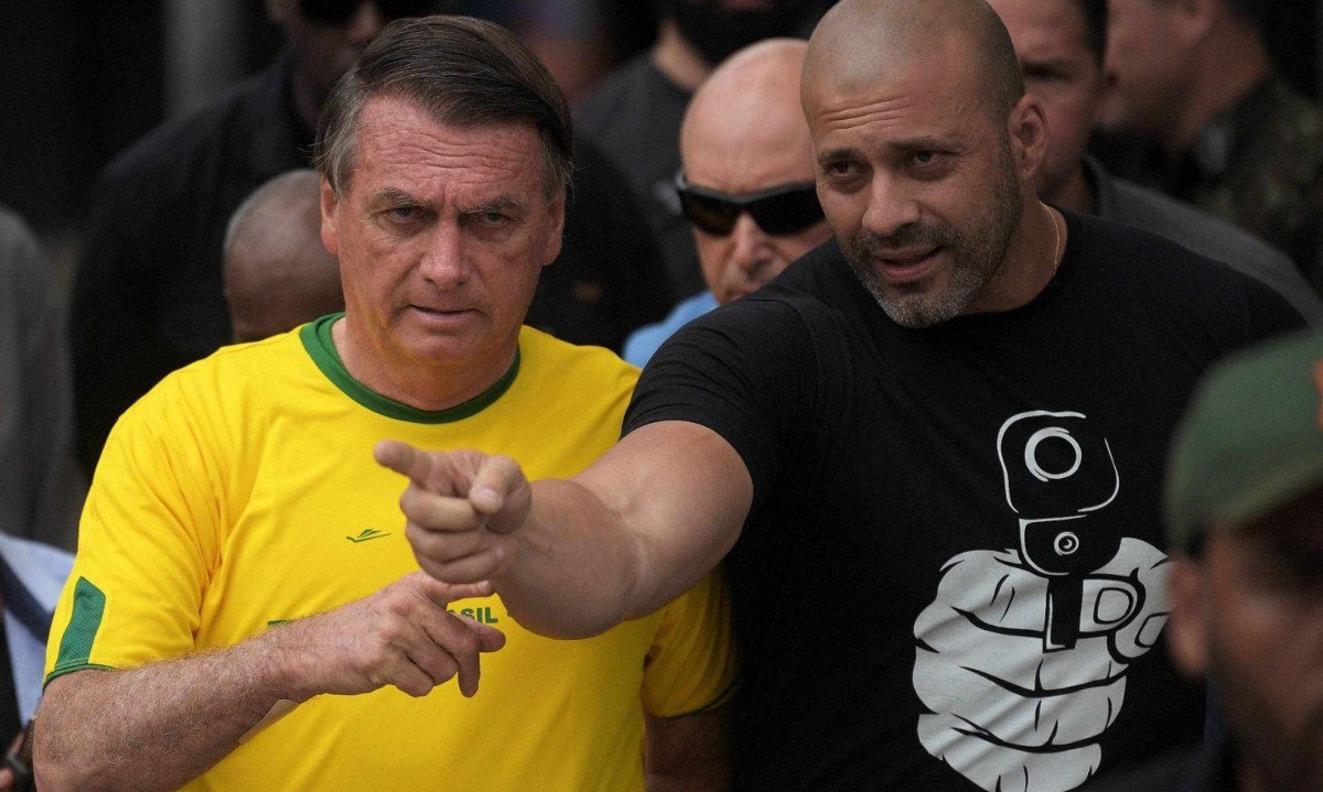 Ex-deputado federal Daniel Silveira, ao lado de Jair Bolsonaro, foi preso após ameaças a ministros do STF -  (crédito: CARL DE SOUZA / AFP))